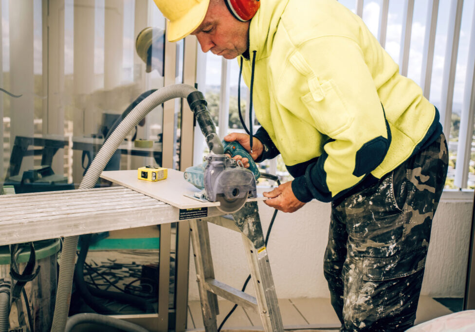 Master cuts the tile using an angle grinder with special diamond disc.